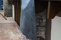 Buttress stripped of veneer brick